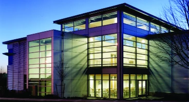 CCC's Wilsonville campus at twilight with lights from the building interior streaming though large windows