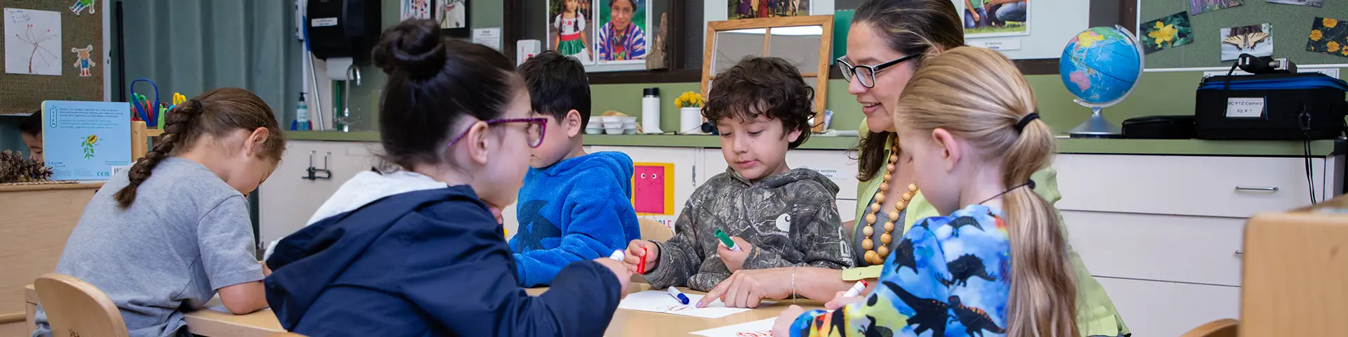 Elementary teacher showing a group of very young students coloring techniques with markers.