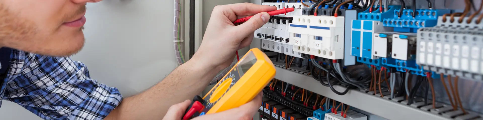 Energy systems technician testing out various hardware components with a voltage tester.