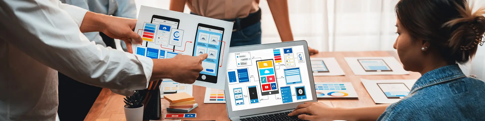 A group of people sharing wireframe ideas for their website's mobile design.