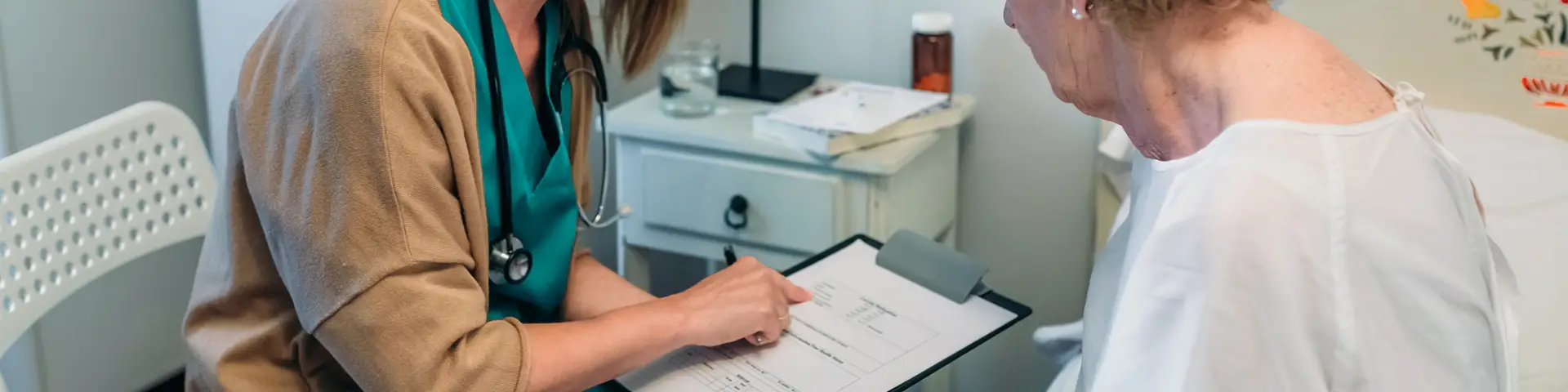 A health care professional reviewing test results with a senior patient.