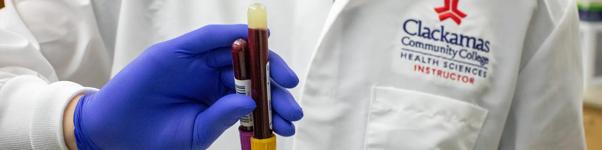Person holding two vials of blood
