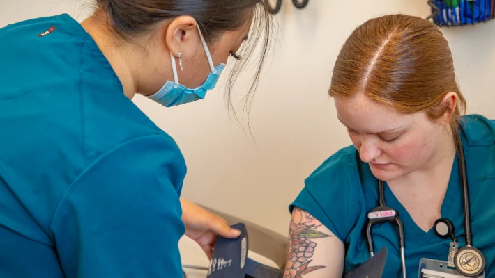 C63A0119 CCC health sciences student practices taking blood pressure on another student