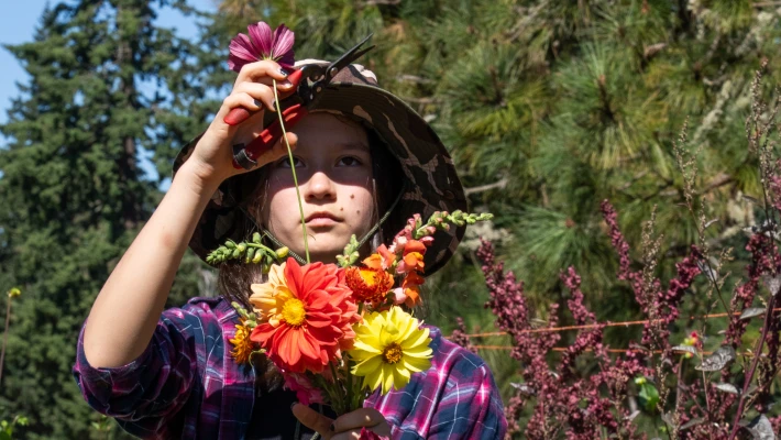 Gardening Student farmer adds a flower to a bouquet