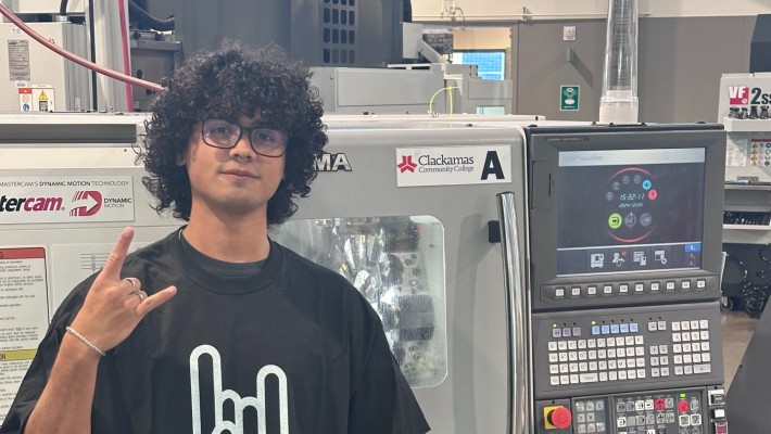 JefferssonUlateSalas Participant in the Metallica Scholars initiative poses in front of CNC machine doing