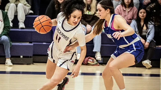 CCC women's basketball player dribbles past an opponent during a game.